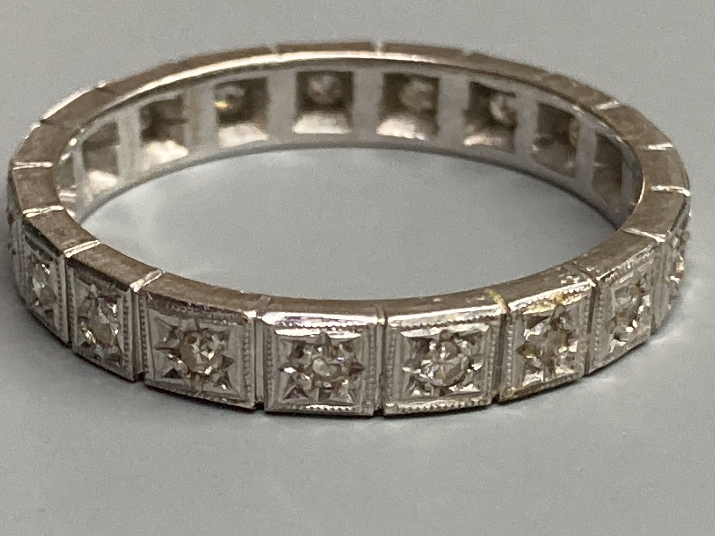 A modern white metal and diamond chip set full eternity ring, total carat weight approx. 0.35ct, size R, gross 4.2 grams.